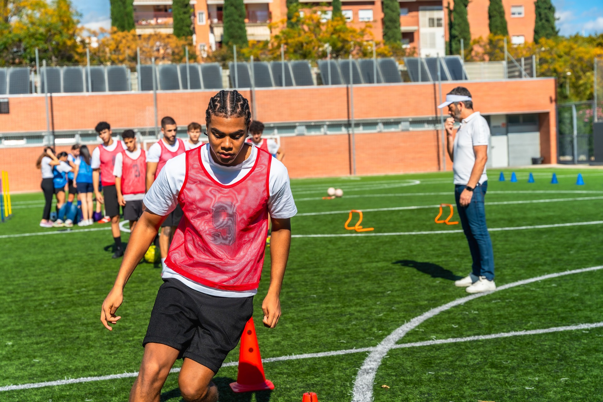 Young men training for soccer drill with coach